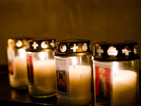 Cinque candele accese con etichette nella chiesa di Maria Strassengel. | © TV Region OberGraz-Mias Photoart