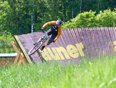 A cyclist curves on a ramp track in nature.