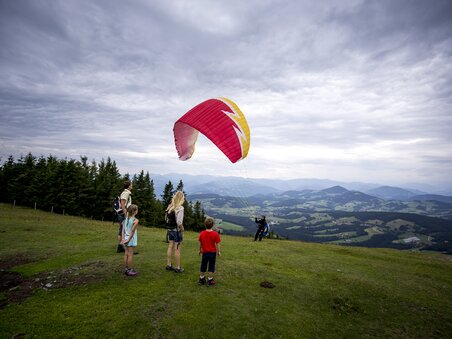 Bambini che osservano un parapendio sullo Schöckl. | © Region Graz - Tom Lamm