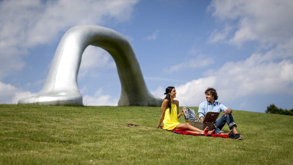 Paar genießt ein Picknick im Österreichischen Skulpturenpark. | © Region Graz - Tom Lamm