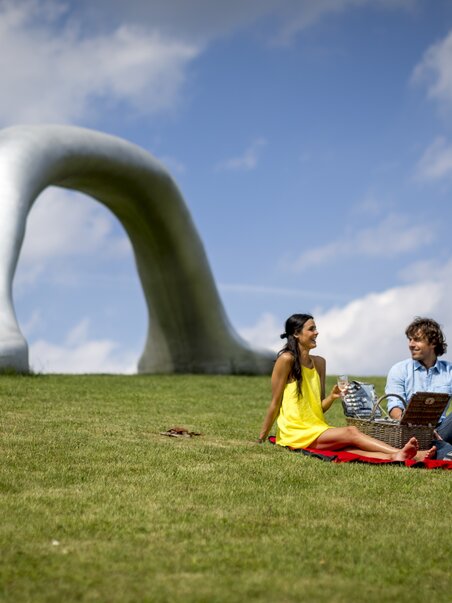 Paar genießt ein Picknick im Österreichischen Skulpturenpark. | © Region Graz - Tom Lamm