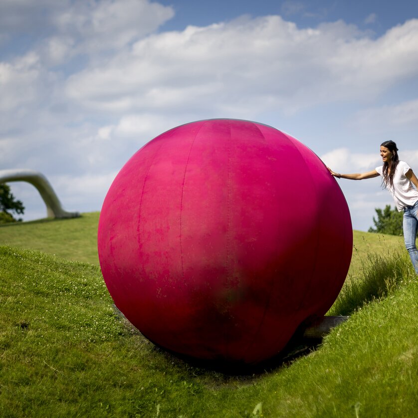 Österreichischer Skulpturenpark, Werner Reiterer | © Region Graz - Tom Lamm Eine Frau mit einer großen pinken Kugel im Österreichischen Skulpturenpark. | © Region Graz - Tom Lamm