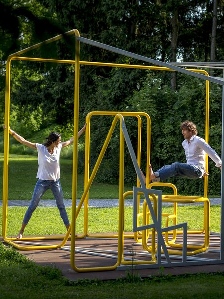 Zwei Personen spielen in einer kreativen Skulptur im Österreichischen Skulpturenpark. | © Region Graz - Tom Lamm