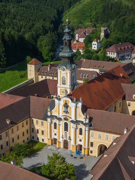 Aerial view of the baroque Stift Rein church in a rural setting. | © Region Graz - PicFly