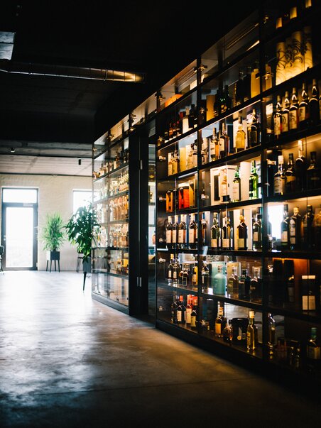 Moderne Bar mit einem gläsernen Regal voller Spirituosen. | © David Gölles