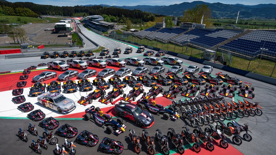 Rennautos, Sportwagen und Motorräder stehen in Formation auf dem Red Bull Ring in Spielberg – Gruppenfoto aller Red Bull-Fahrzeuge. | © Red Bull Content Pool
