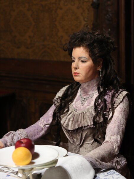 Portrait einer Dame im viktorianischen Stil, die an einem Tisch sitzt mit einem Apfel und einer Zitrone darauf | © Bardeau - Sonja Skalnik