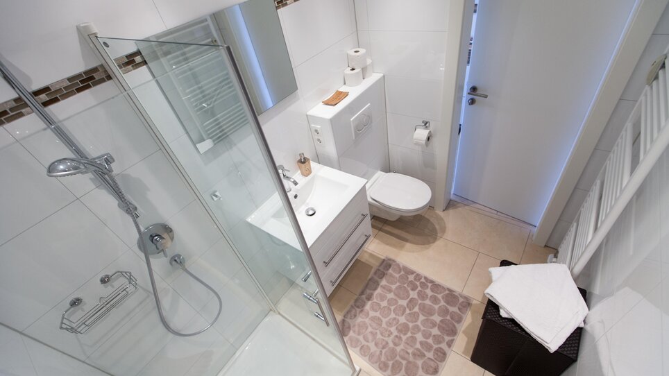 Compact modern bathroom featuring a shower, sink, and toilet. | © R. Kaiser