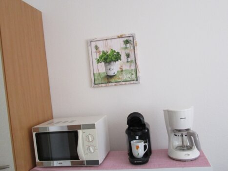 Kitchen area with microwave, coffee machine, and decor. | © Appartement Anne-Marie