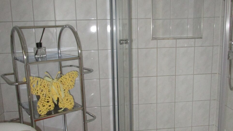 Bagno con doccia, asciugamani e decorazioni. | © Appartement Anne-Marie