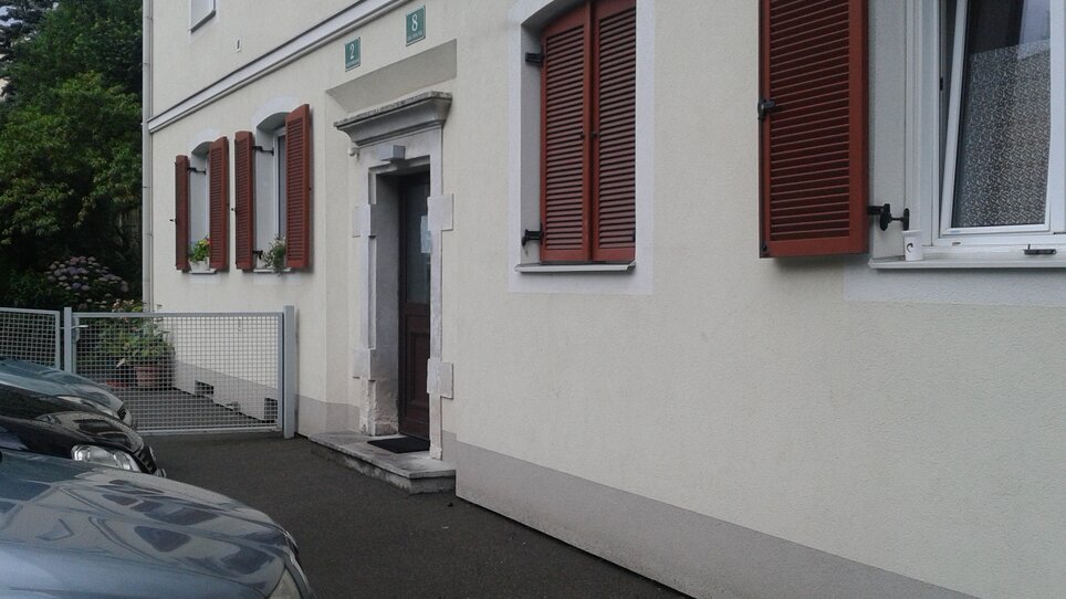Der Eingang zu einem Wohngebäude mit roten Fensterläden | © Appartement St. Leonhard