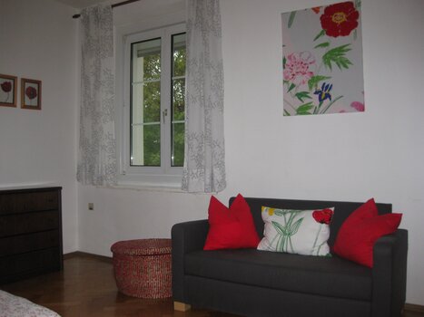 Helles Zimmer mit Fenster und Couch. | © Appartement St. Leonhard