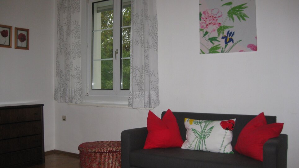 Helles Zimmer mit Fenster und Couch. | © Appartement St. Leonhard