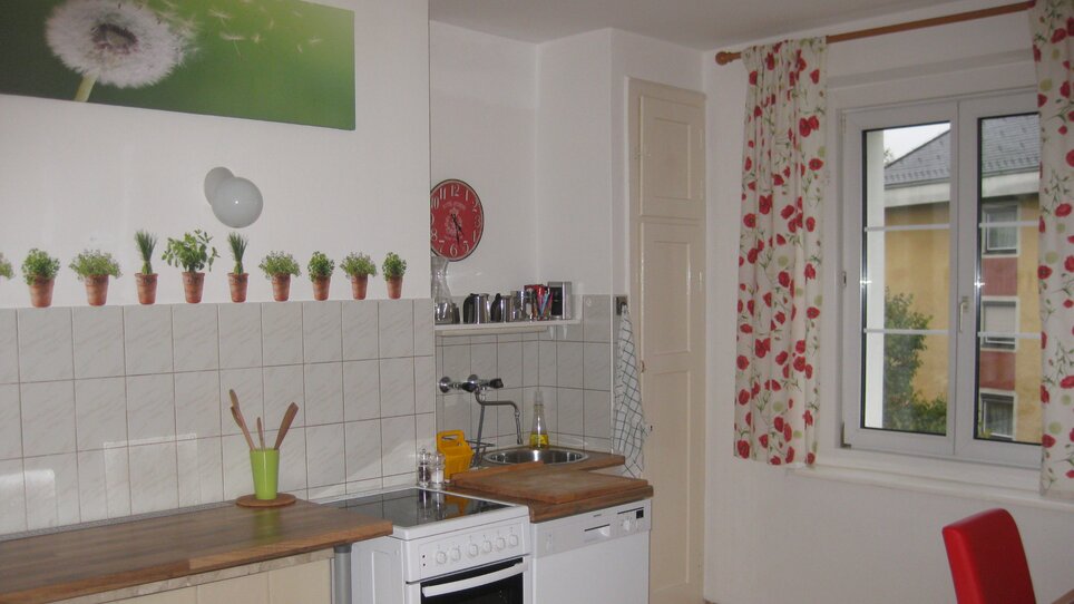 Helle Küchenzeile mit Fenster und Deko. | © Appartement St. Leonhard
