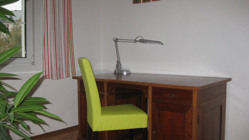 Schreibtisch mit Stuhl und Fensterblick. | © Appartement St. Leonhard
