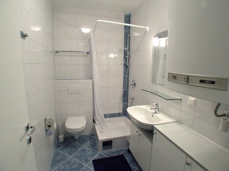 Bathroom with shower, toilet, and sink. | © Patrick Wund