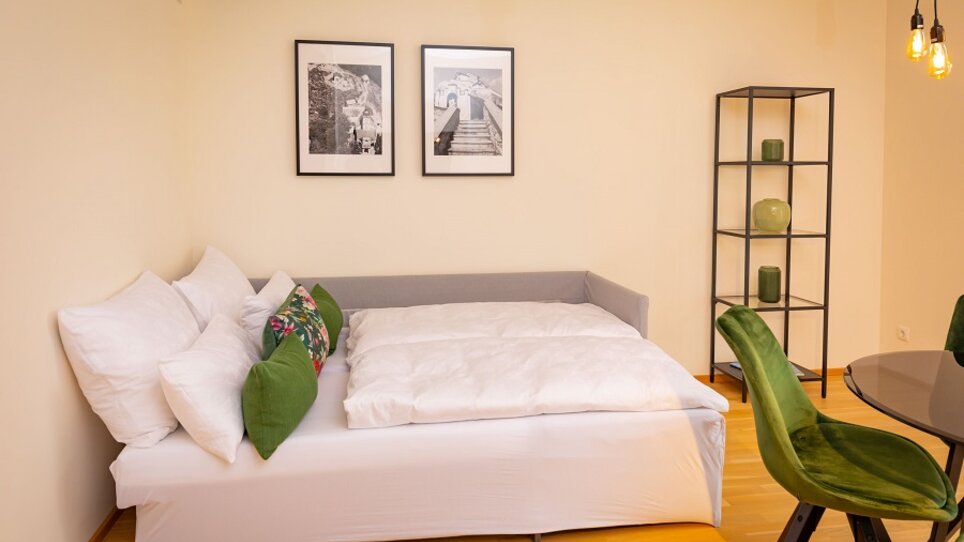 Gemütliches Schlafzimmer mit Sofa und Bildern. | © Appartements Kalvarienberg