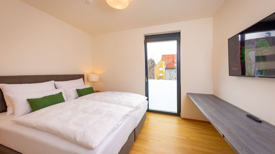 Helles Schlafzimmer mit großen Fenstern. | © Appartements Kalvarienberg
