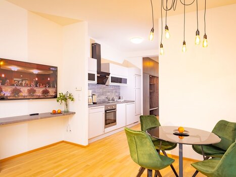 Bright kitchen with dining table and TV.