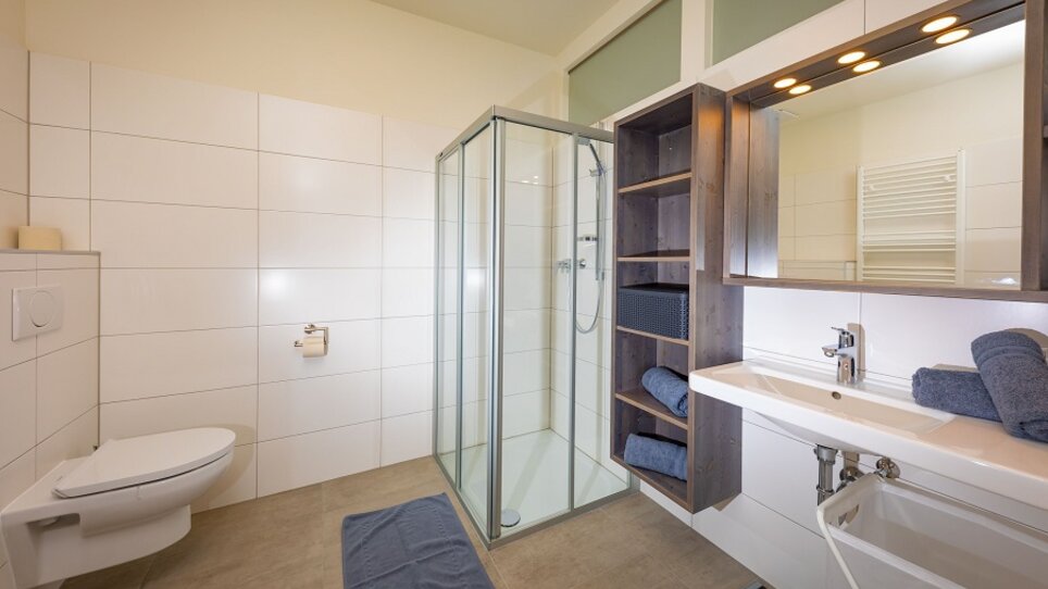 Helles, modernes Badezimmer mit Dusche.