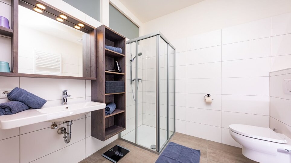 Modernes Badezimmer mit Dusche und Waschbecken.