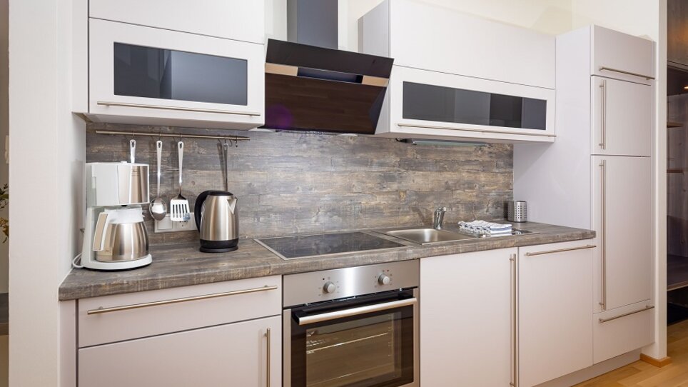 Küche mit modernen Geräten und eleganter Einrichtung.