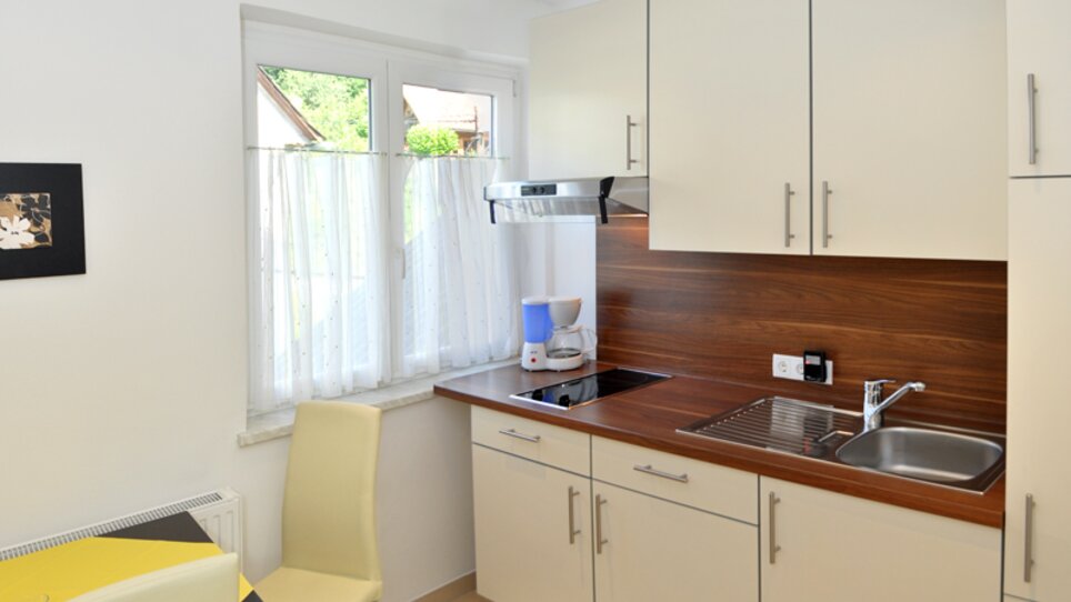 Cucina luminosa e moderna con tavolo e sedie. | © Steinbichler