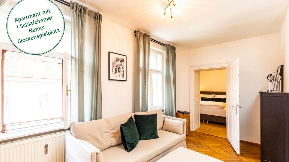 Un soggiorno con divano, sedia e accesso a una camera da letto in un appartamento a Graz.