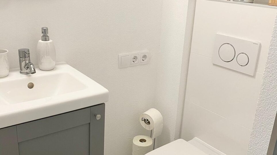 Modern bathroom with sink and toilet. | © CityStage Studio