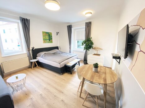 Spazio abitativo luminoso con letto e tavolo da pranzo. | © R. Arnus