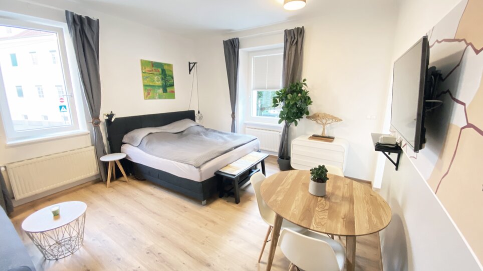 Bright living space with bed and dining table. | © R. Arnus