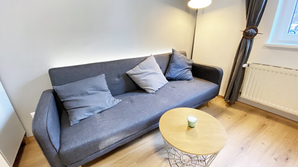 Cozy living room with couch and table. | © R. Arnus