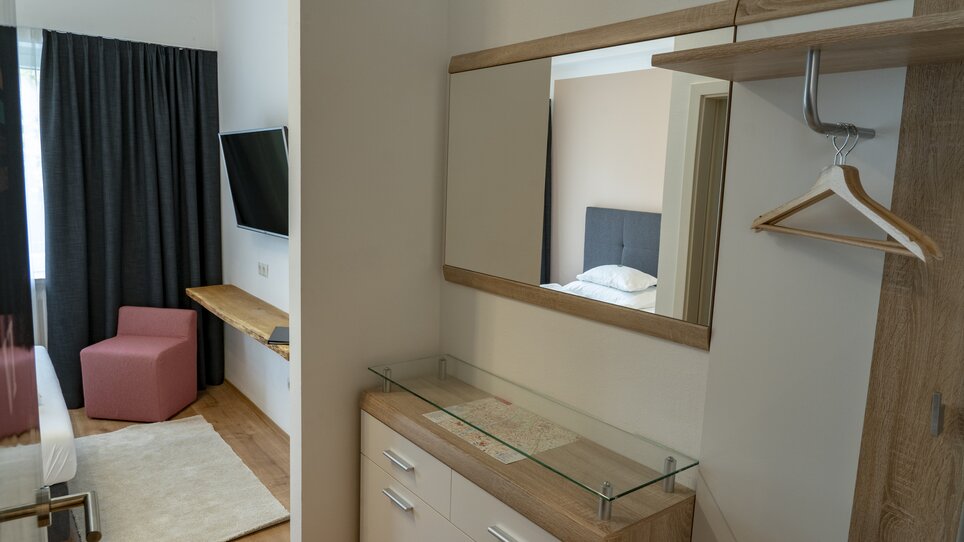 View of a room in the Guesthouse Mosshammer with TV, mirror, and chair. | © Mosshammer