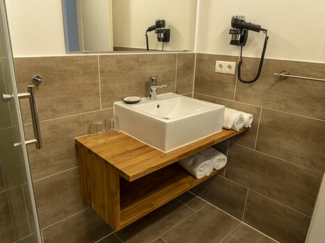 Badezimmer mit Waschbecken und Handtüchern im Gästehaus Mosshammer. | © Mosshammer