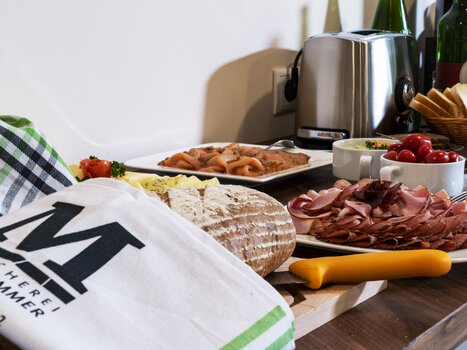 Ein Tisch mit Brot, Wurst und Salat im Gästehaus Mosshammer. | © Mosshammer