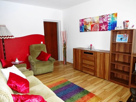 Un soggiorno con arredi accoglienti e un tappeto colorato. | © Gartenvilla Irene