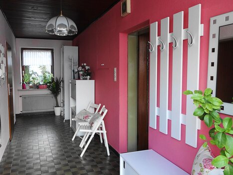 Corridoio nella Gartenvilla Irene con piante e mobili. | © Gartenvilla Irene