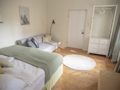 Camera luminosa con letto matrimoniale, divano e armadio. | © GrazRentals