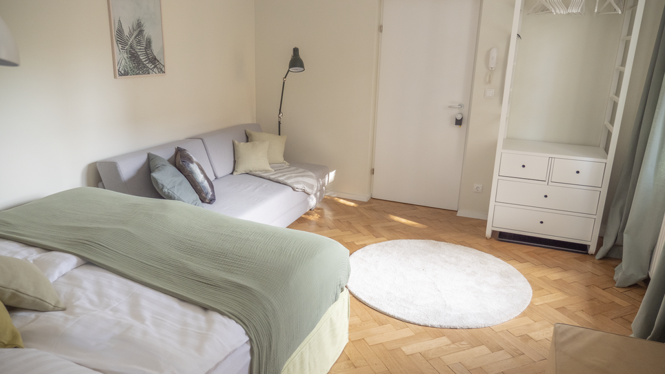 Camera luminosa con letto matrimoniale, divano e armadio. | © GrazRentals