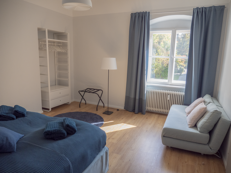 Una camera con un letto, divano e finestra. | © GrazRentals