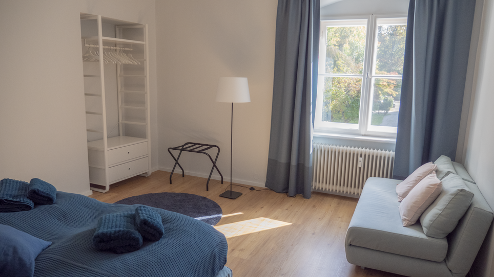 Una camera con un letto, divano e finestra. | © GrazRentals