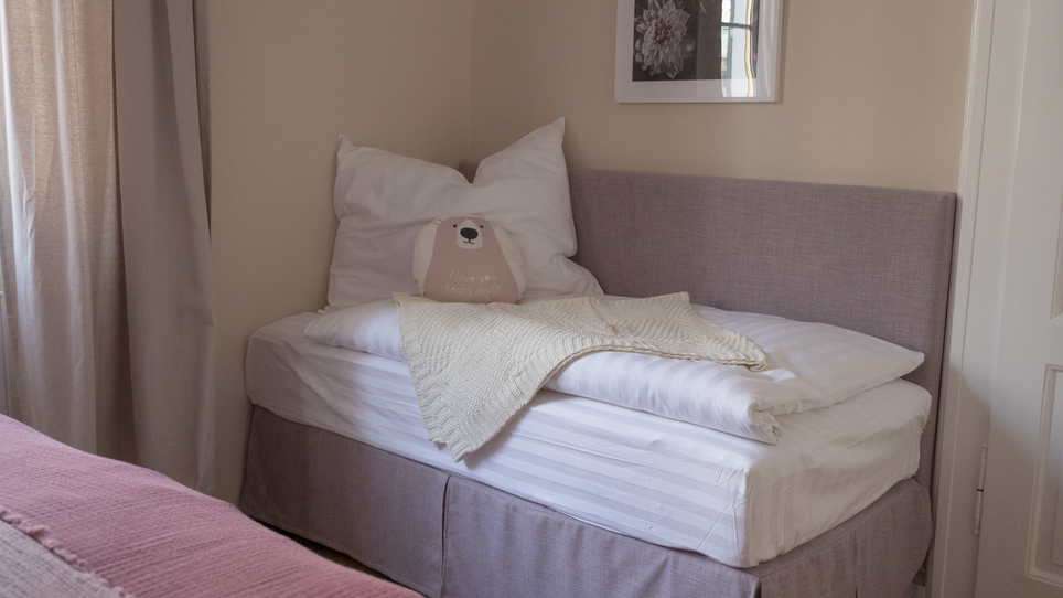 Un letto con cuscini e una coperta in una stanza luminosa. | © GrazRentals