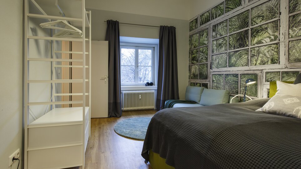 Stanza luminosa con letto, armadio e finestra. | © GrazRentals