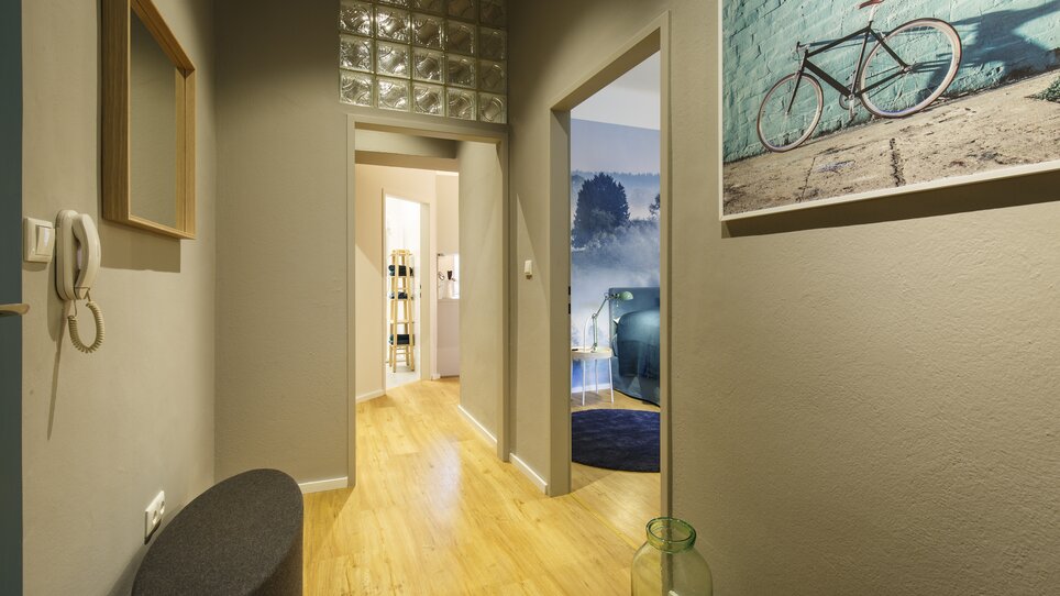 Corridoio con porte e immagini in un appartamento moderno. | © GrazRentals