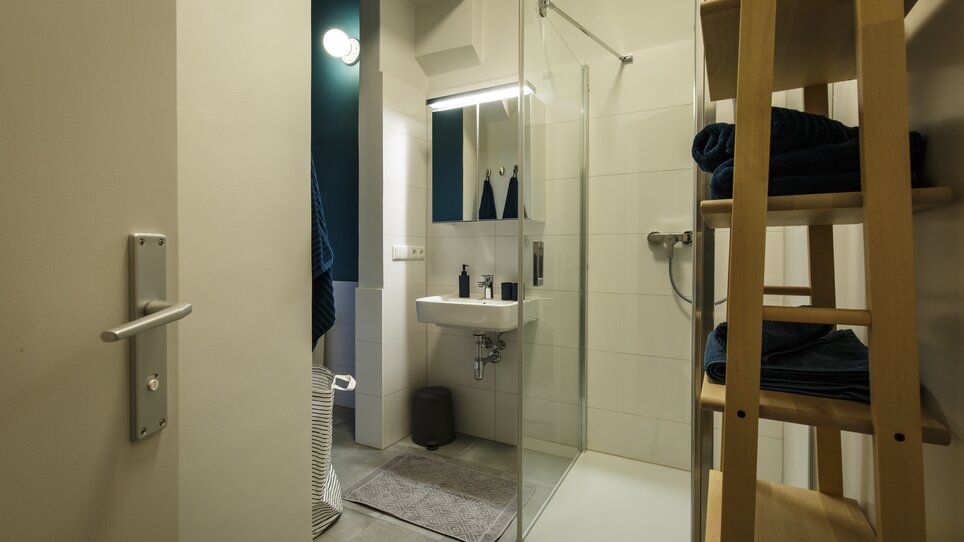 Bagno con doccia, lavandino e asciugamani. | © GrazRentals