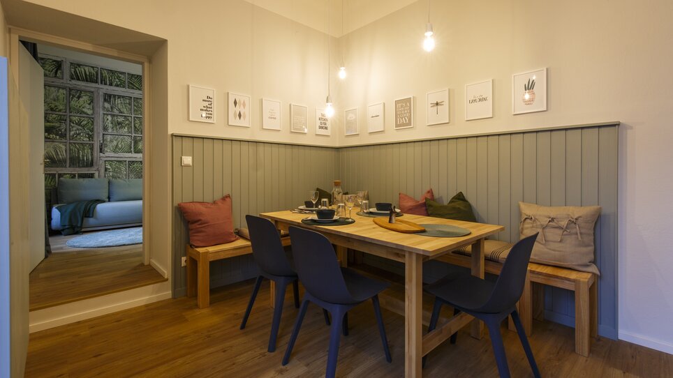 Area pranzo con tavolo di legno, sedie e decorazioni. | © GrazRentals