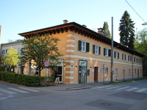 Vista di un edificio con alberi e segnali stradali. | © GrazRentals