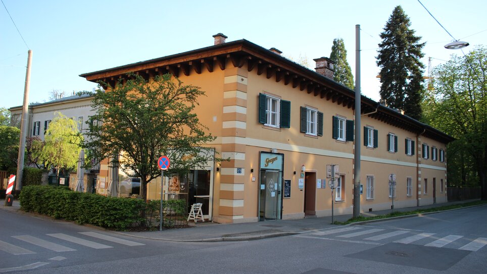 Vista di un edificio con alberi e segnali stradali. | © GrazRentals