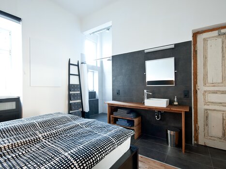 Interior of a room with a bed and sink. | © Grocholl