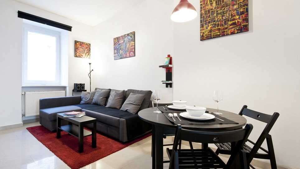 Interno di un appartamento con divano e tavolo da pranzo. | © Grocholl